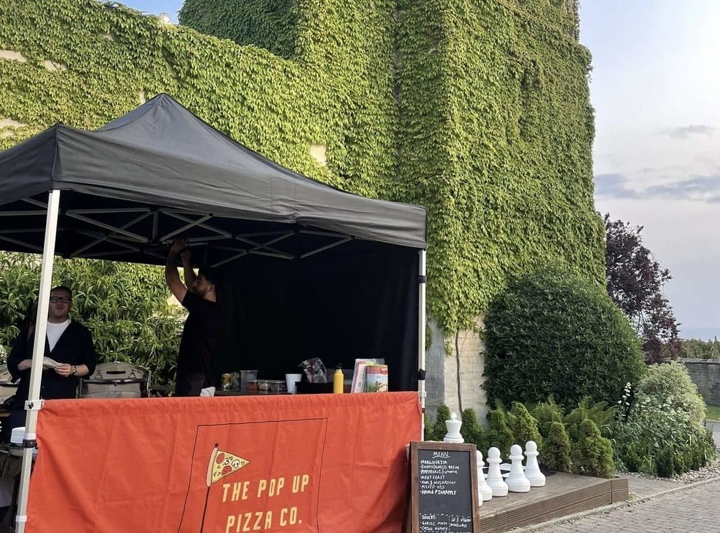 The Pop Up Pizza Co's stall set up at an ivy-covered venue